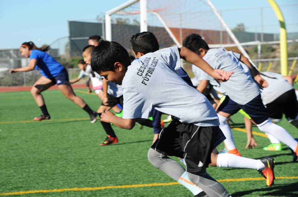 During a Saturday afternoon practice, CCFA’s Carissa Purnell leads young members like Francisco Moreno in conditioning exercises at a local high school. (c)Jay_Dunn_1_773_817_0547